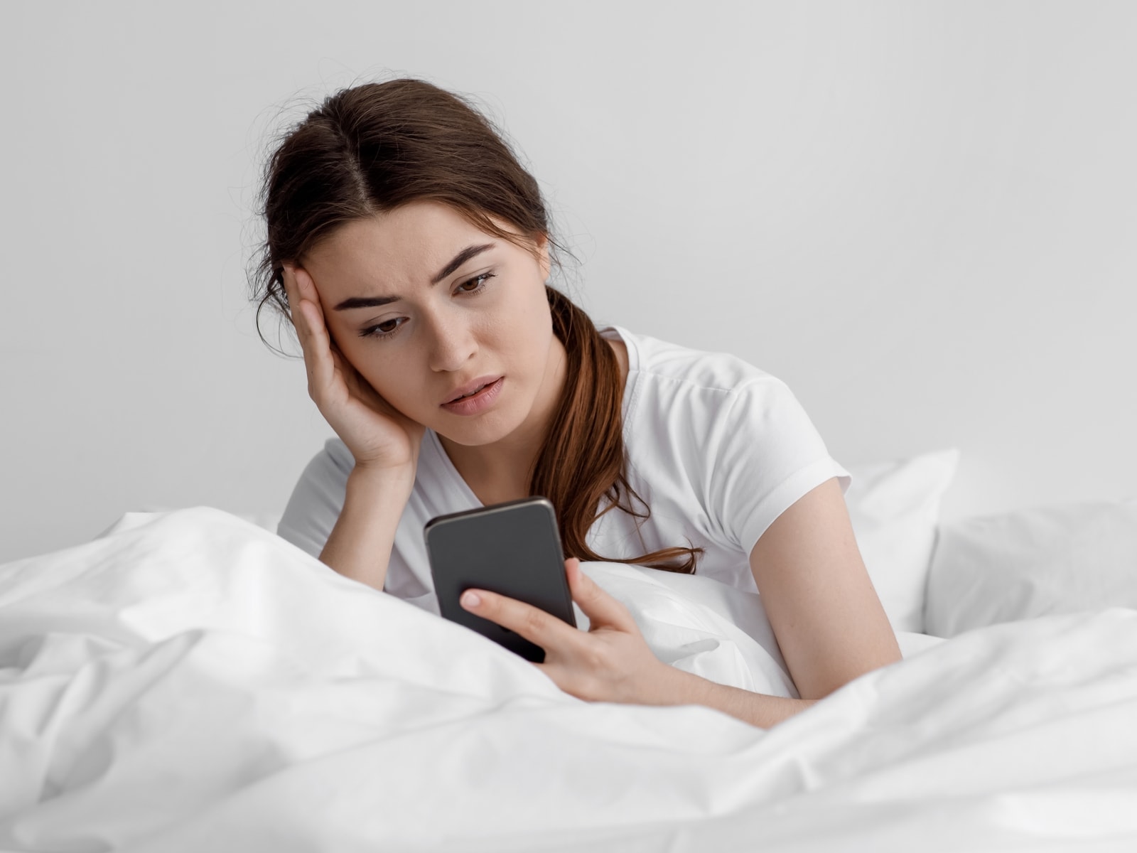 Pige ser bekymret på sin mobil