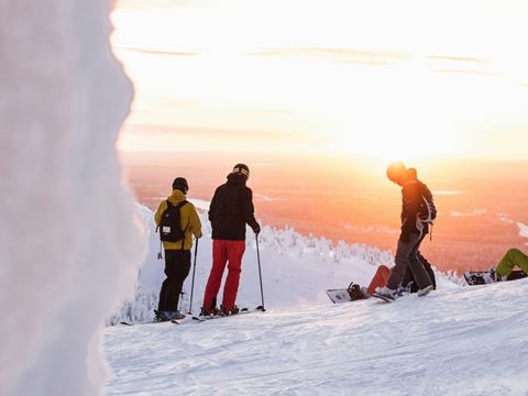 Billede af personer på ski på bjerg med solnedgang