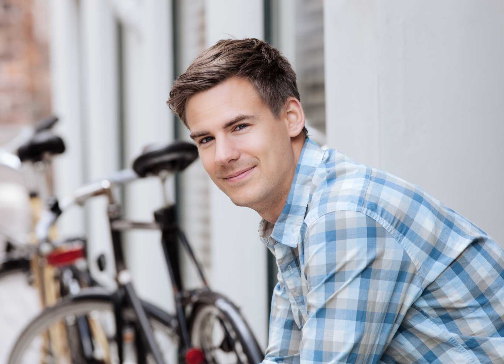 Tre unge studerende sidder sammen ved et bord og læser i bøger, mens de smiler og diskuterer. Kaffe og æbler står på bordet.