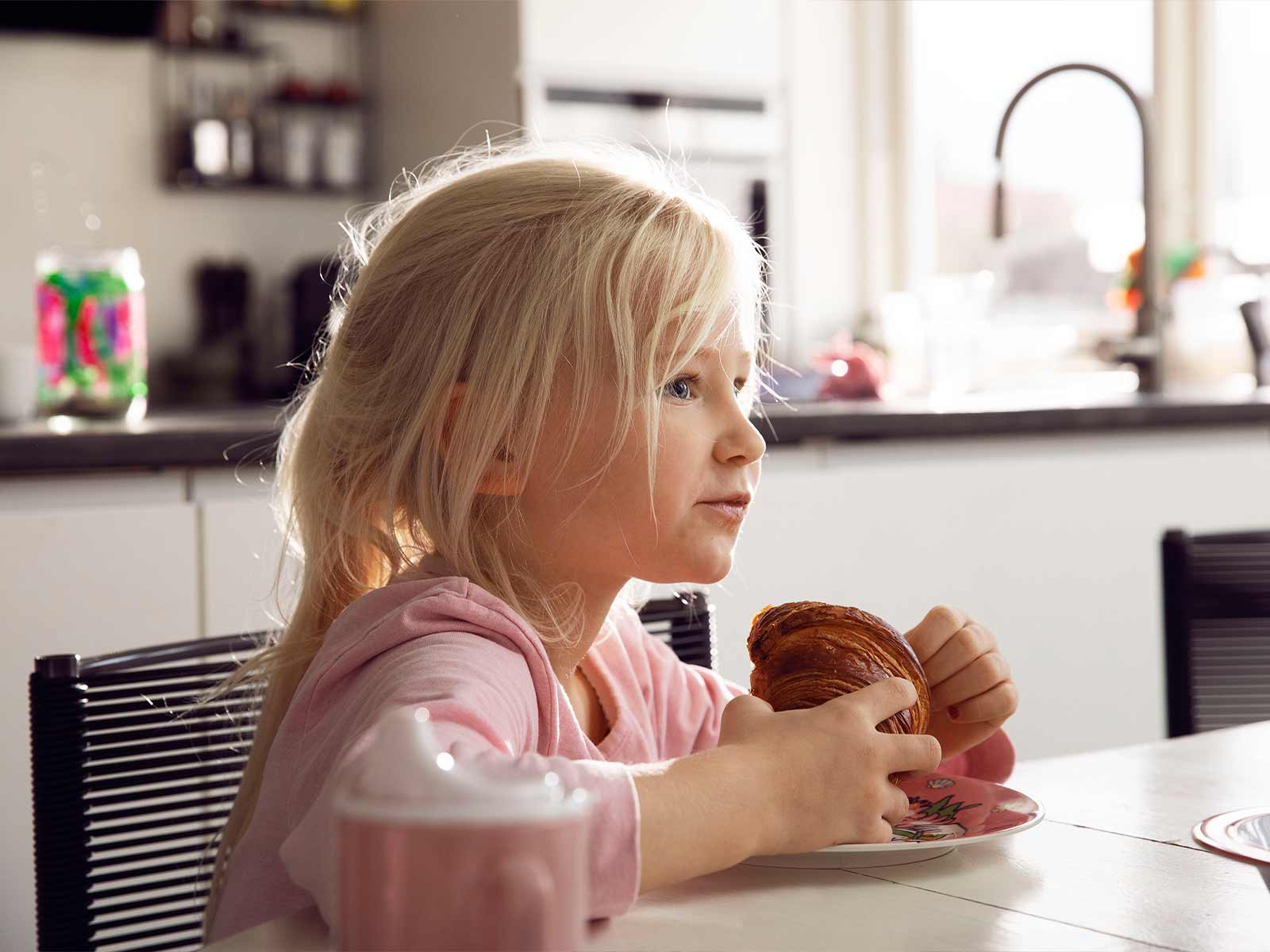 Pige spiser croissant