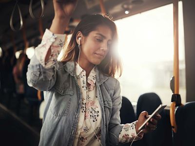 Ung kvinde med smartphone i bus