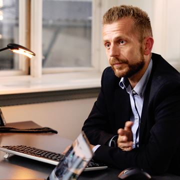 Person i jakkesæt får økonomisk rådgivning i banken.
