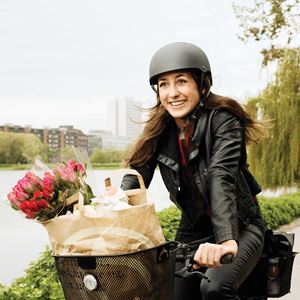 Kvinde med blomster i cykelkurv