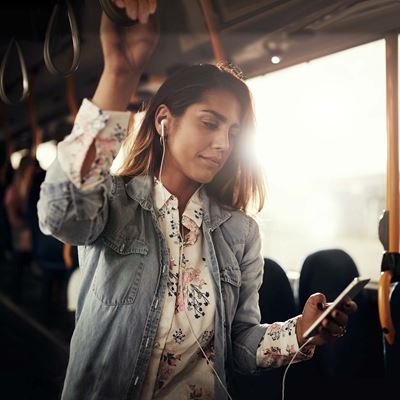 Ung kvinde i bus med sin smartphone