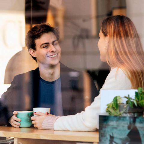 Ung mand og kvinde drikker kaffe