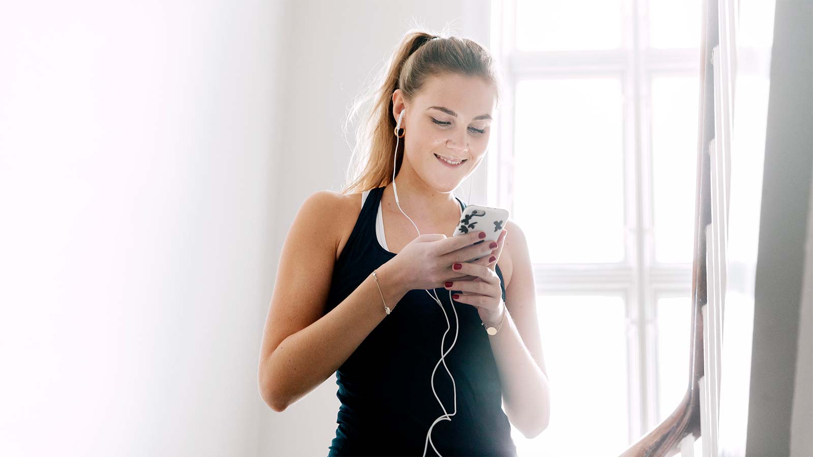 Ung kvinde lytter til musik på mobil